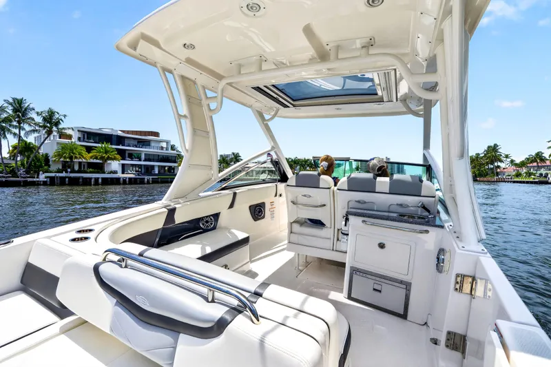 Slide: The Image of 2023 Chaparral 280 OSX boat interior, featuring luxurious seating and modern amenities on a sunny waterfront. - 71