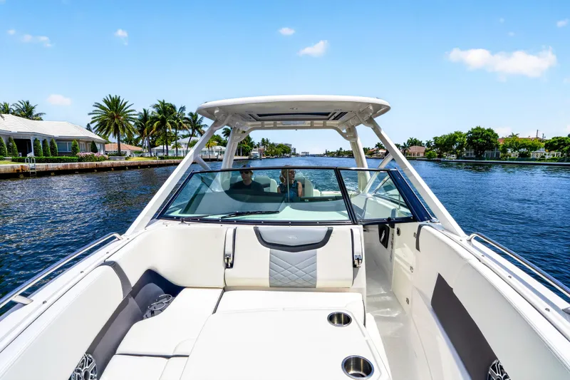 Slide: The Image of 2023 Chaparral 280 OSX boat cruising on a scenic waterway with palm trees. - 33