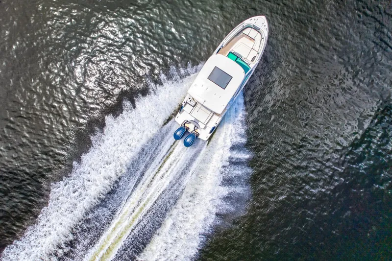 Slide: The Image of Aerial view of 2023 Chaparral 280 OSX boat speeding on water, creating a dynamic wake. - 2
