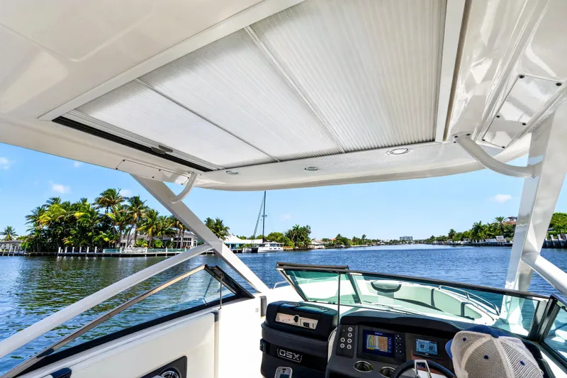 Slide: The Image of 2023 Chaparral 280 OSX boat interior with view of serene waterfront and lush greenery. - 79