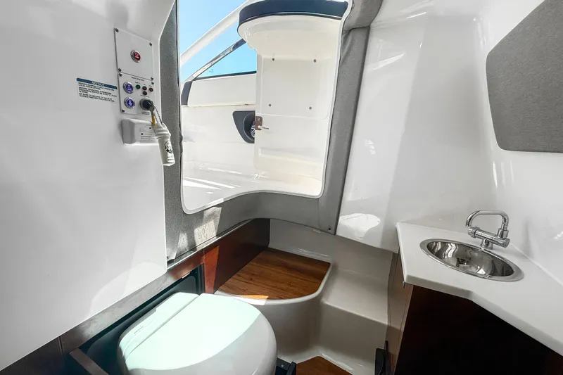 Slide: The Image of 2023 Chaparral 280 OSX boat interior with compact bathroom and sink. - 40