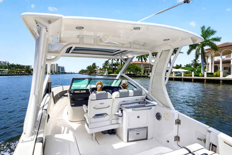 Slide: The Image of 2023 Chaparral 280 OSX boat cruising on a scenic waterway with palm trees and luxury homes. - 29