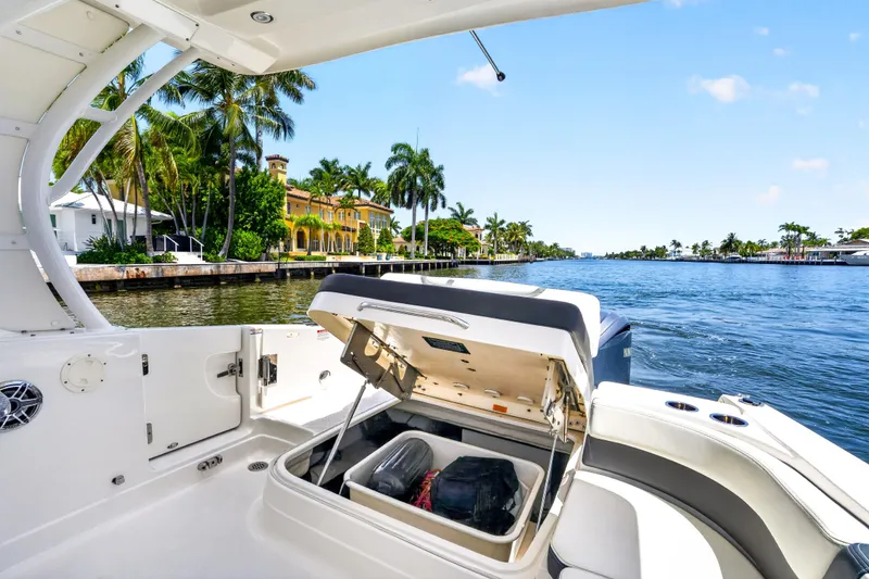 Slide: The Image of 2023 Chaparral 280 OSX boat interior with open storage, scenic waterfront view. - 76