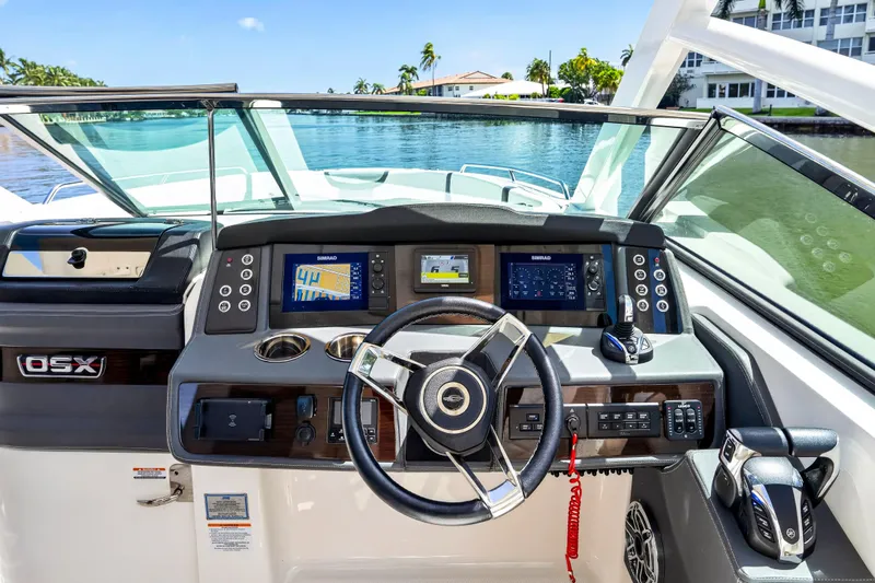 Slide: The Image of 2023 Chaparral 280 OSX boat dashboard with navigation screens and steering wheel. - 47