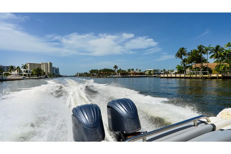 Slide: The Image of 2023 Chaparral 280 OSX cruising on a scenic waterway with palm trees and buildings. - 87