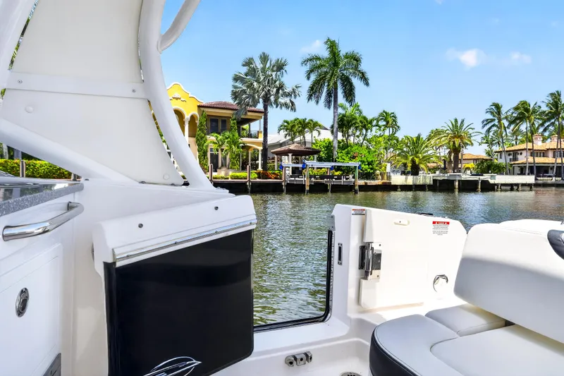 Slide: The Image of 2023 Chaparral 280 OSX boat interior with waterfront view and palm trees. - 19