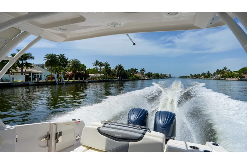 Slide: The Image of 2023 Chaparral 280 OSX cruising on a scenic waterway with palm trees and clear skies. - 74