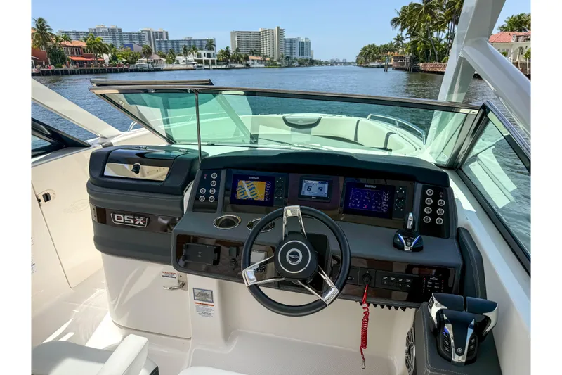 Slide: The Image of 2023 Chaparral 280 OSX boat dashboard with modern controls and waterfront view. - 59