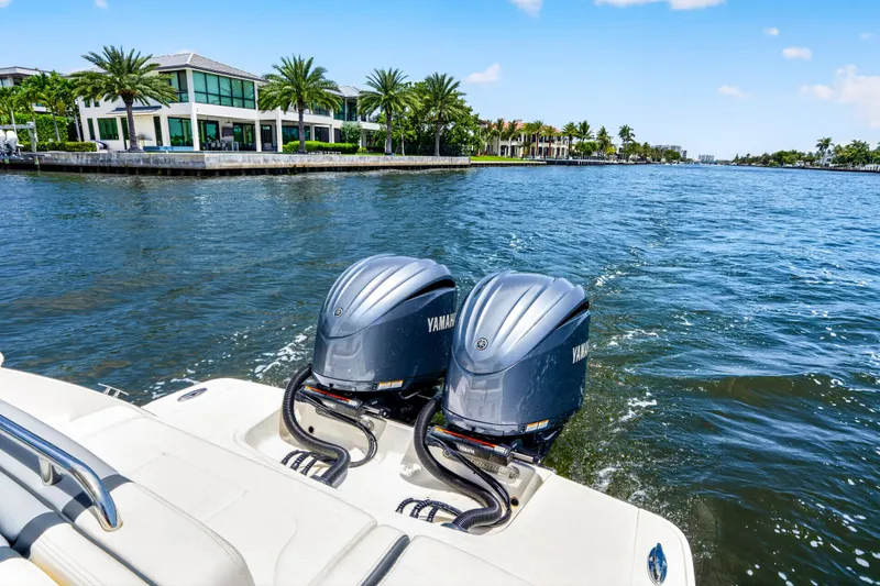 Slide: The Image of 2023 Chaparral 280 OSX boat with dual Yamaha engines cruising on a scenic waterway. - 84