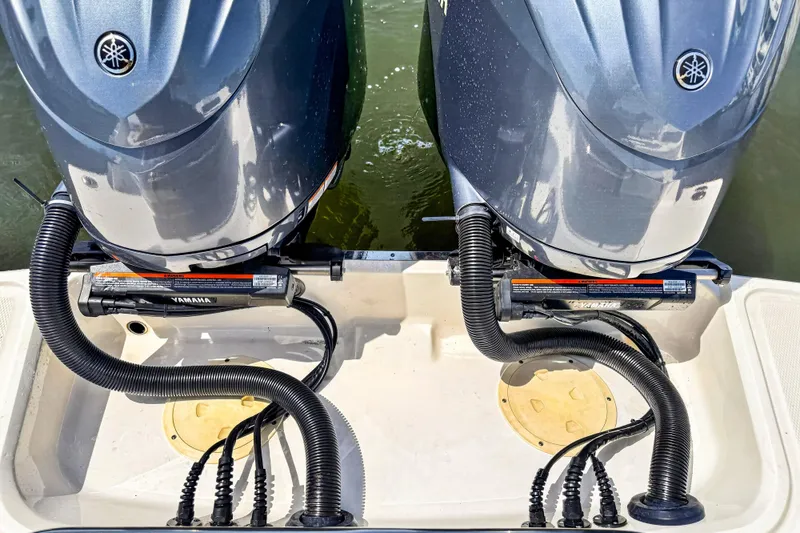 Slide: The Image of Twin Yamaha outboard engines on a 2023 Chaparral 280 OSX boat, docked on water. - 86