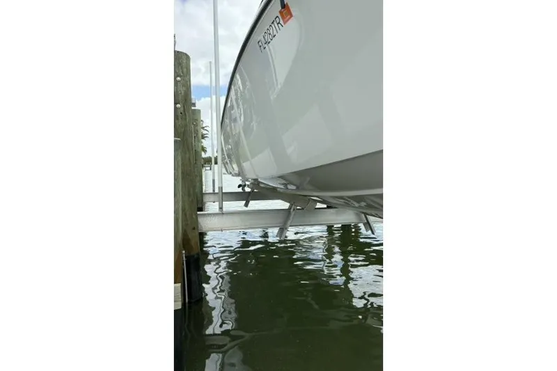 Slide: The Image of 2024 Fountain 32 NX Sportfish boat on lift, docked above water. - 34