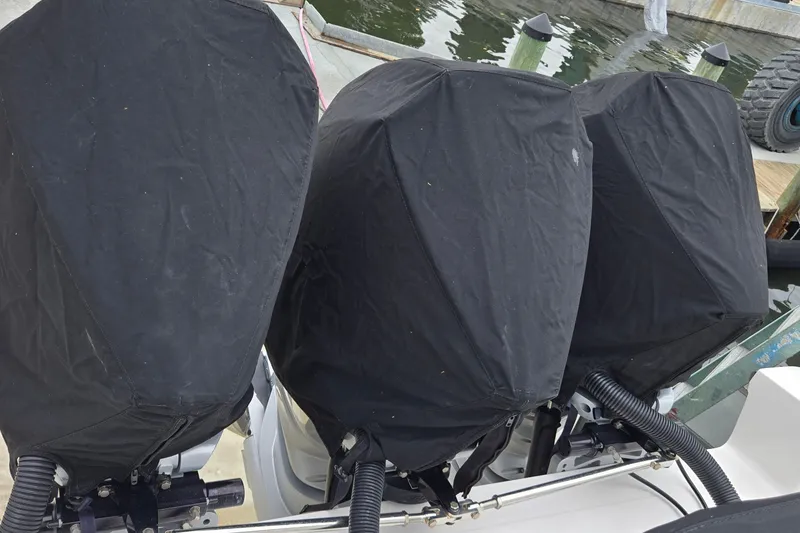 Slide: The Image of Three covered outboard motors on a 2024 Fountain 32 NX Sportfish boat. - 44