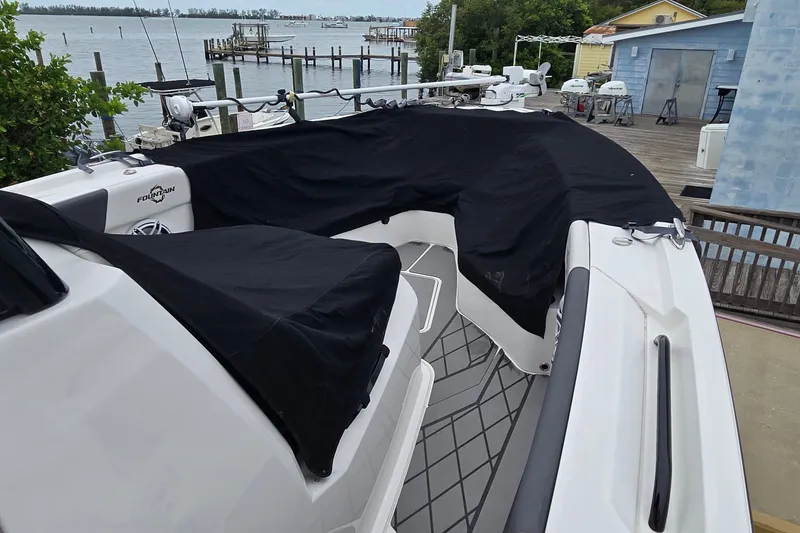 Slide: The Image of 2024 Fountain 32 NX Sportfish boat with black covers docked by the water. - 46