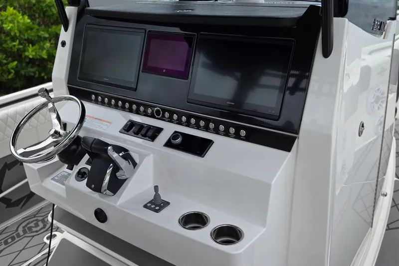 Slide: The Image of 2024 Fountain 32 NX Sportfish boat dashboard with steering wheel and electronic displays. - 25