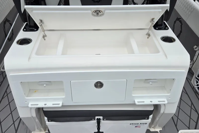 Slide: The Image of 2024 Fountain 32 NX Sportfish boat interior with open storage compartments and cup holders. - 19