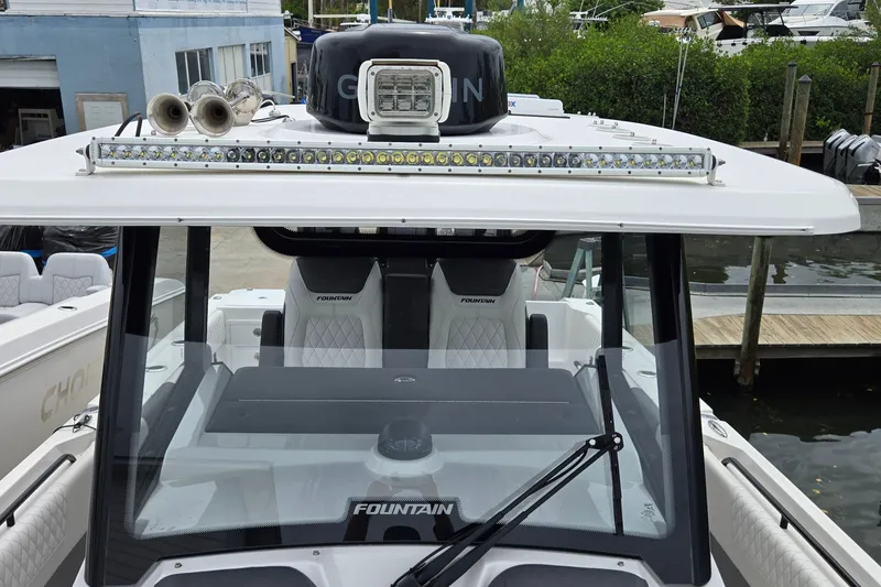 Slide: The Image of 2024 Fountain 32 NX Sportfish boat with advanced lighting and sleek design at a marina. - 41