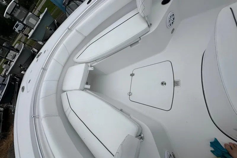 Slide: The Image of 2026 Sportsman Open 232 Center Console boat interior with white seating and storage compartments. - 26