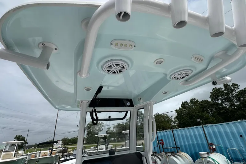Slide: The Image of 2026 Sportsman Open 232 Center Console boat with speakers and rod holders on the T-top. - 37