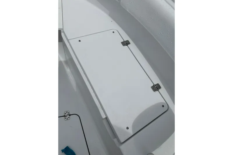 Slide: The Image of 2026 Sportsman Open 232 Center Console boat storage compartment with white hinged lid. - 30