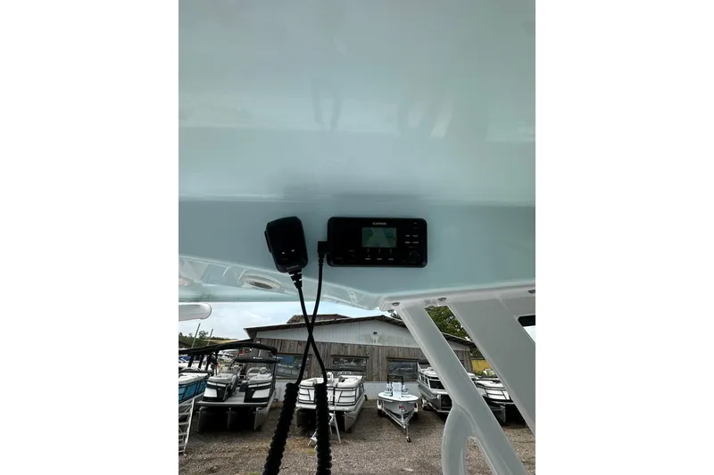 Slide: The Image of 2026 Sportsman Open 232 Center Console boat with Garmin electronics, docked near other boats. - 38