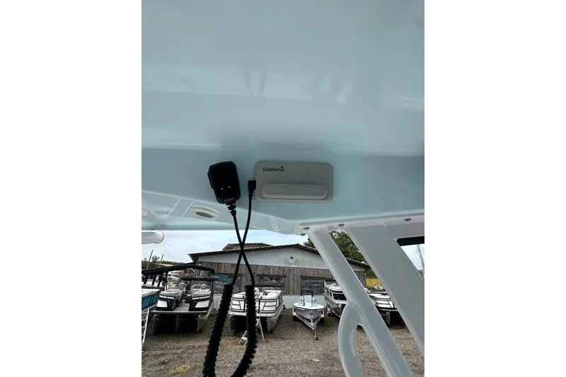 Slide: The Image of 2026 Sportsman Open 232 Center Console boat with Garmin equipment, docked near other boats. - 39