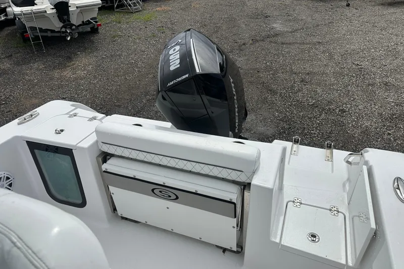 Slide: The Image of 2026 Sportsman Open 232 Center Console boat with Mercury outboard engine, parked on gravel. - 36
