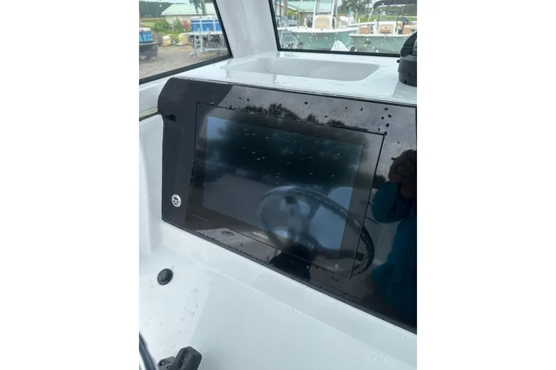 Slide: The Image of 2026 Sportsman Open 232 Center Console dashboard with Garmin display in wet conditions. - 43