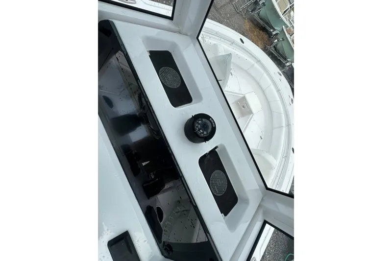 Slide: The Image of 2026 Sportsman Open 232 Center Console boat interior with compass and storage compartments. - 42