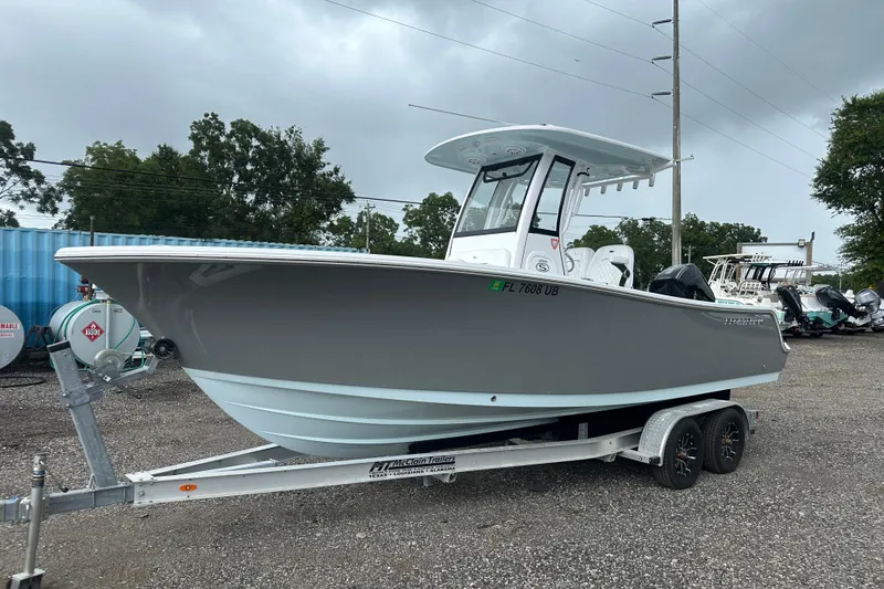 The Image of 2026 Sportsman Open 232 Center Console boat on trailer, parked outdoors. - 0