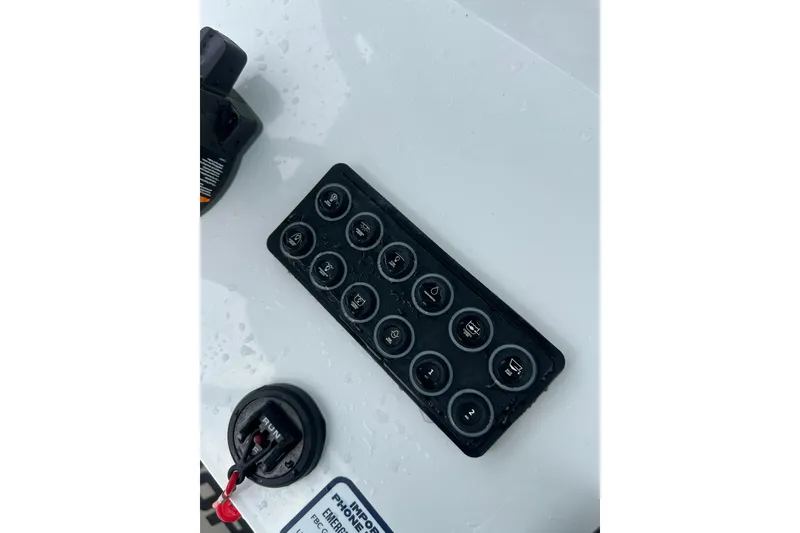 Slide: The Image of Control panel of 2026 Sportsman Open 232 Center Console boat with multiple switches. - 44