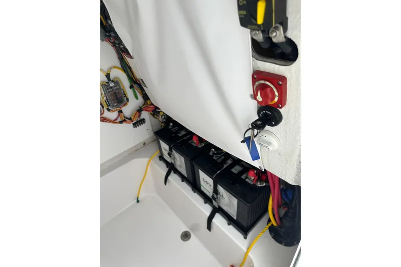 Slide: The Image of 2026 Sportsman Open 232 Center Console boat battery compartment with wiring and switches. - 33