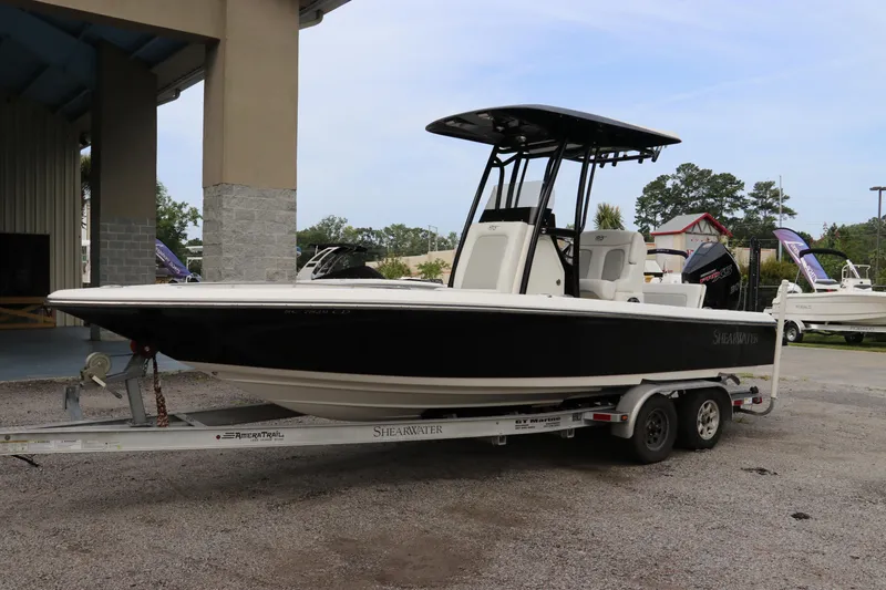 Slide: The Image of 2018 ShearWater 25 LTZ boat on trailer, parked outdoors near a building. - 3