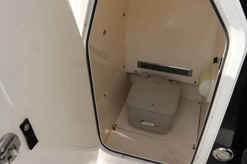 Slide: The Image of 2018 ShearWater 25 LTZ boat interior with compact portable toilet. - 33