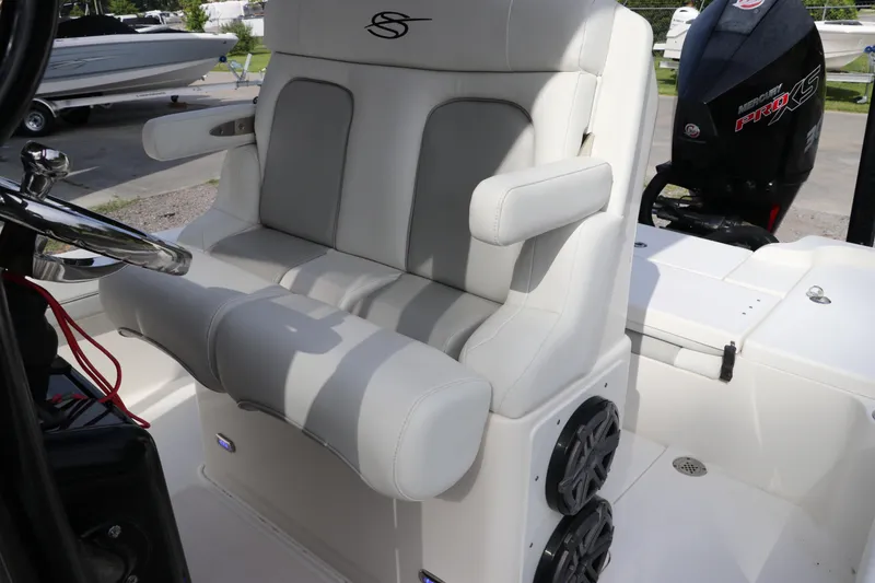 Slide: The Image of 2018 ShearWater 25 LTZ boat interior with cushioned seating and steering wheel. - 19