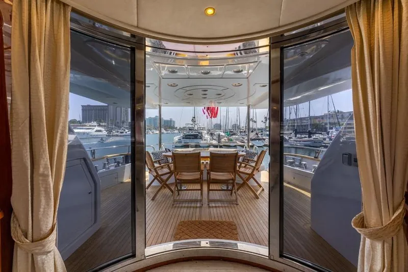 Slide: The Image of Luxurious Azimut 85 Ultimate yacht interior with marina view, featuring elegant wooden deck and seating. - 10