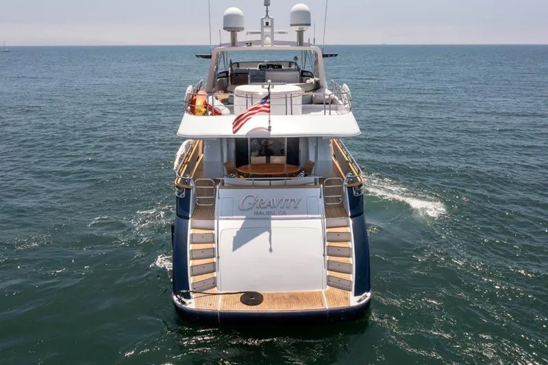 Slide: The Image of Azimut 85 Ultimate yacht from 2000 cruising on open water, rear view with American flag. - 3