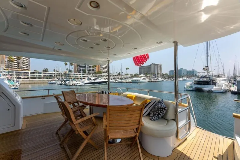 Slide: The Image of Luxurious 2000 Azimut 85 Ultimate yacht deck with marina view, featuring elegant seating and dining area. - 9