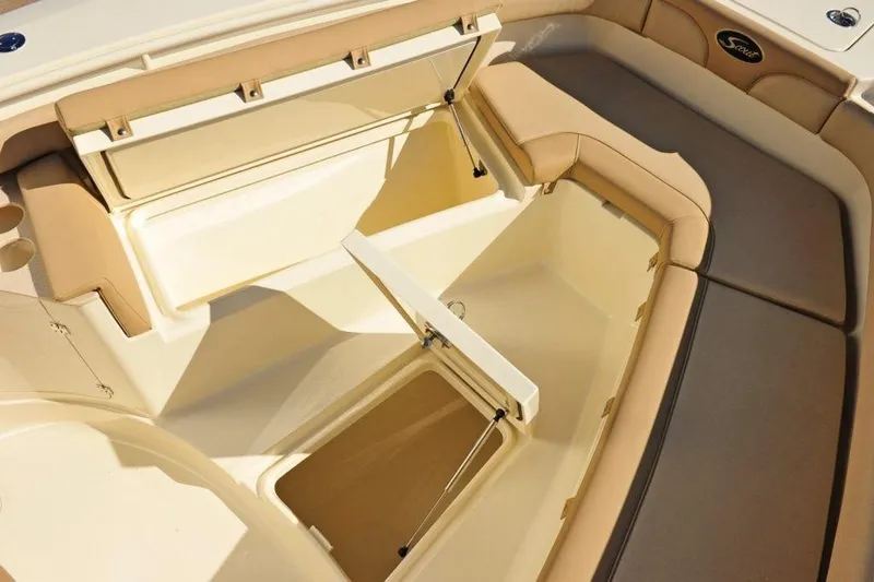 Slide: The Image of The image shows the bow area of a Scout 277 LXF boat with beige upholstery and storage. - 11