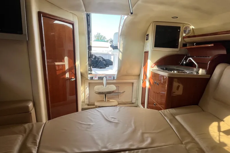 Slide: The Image of Interior of a 2008 Cobalt 323 boat featuring a kitchenette and seating area. - 34
