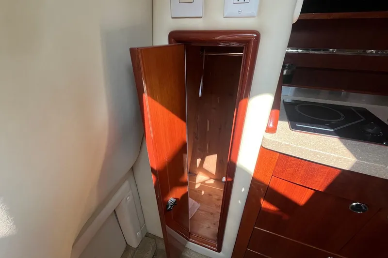 Slide: The Image of Interior of a 2008 Cobalt 323 boat showing a wooden cabinet and kitchenette area. - 28