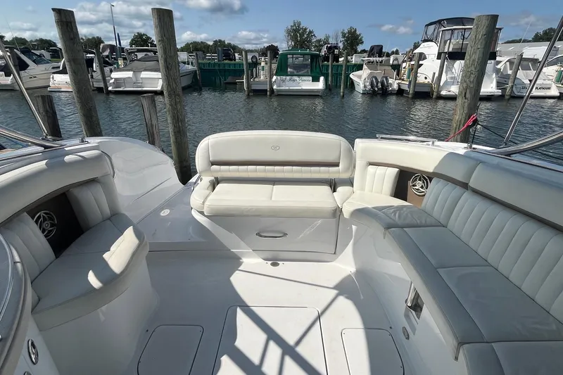 Slide: The Image of 2008 Cobalt 323 boat interior with white seating at a marina dock. - 11