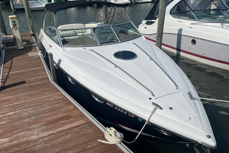Slide: The Image of 2008 Cobalt 323 boat docked at marina, featuring sleek white and black design. - 2