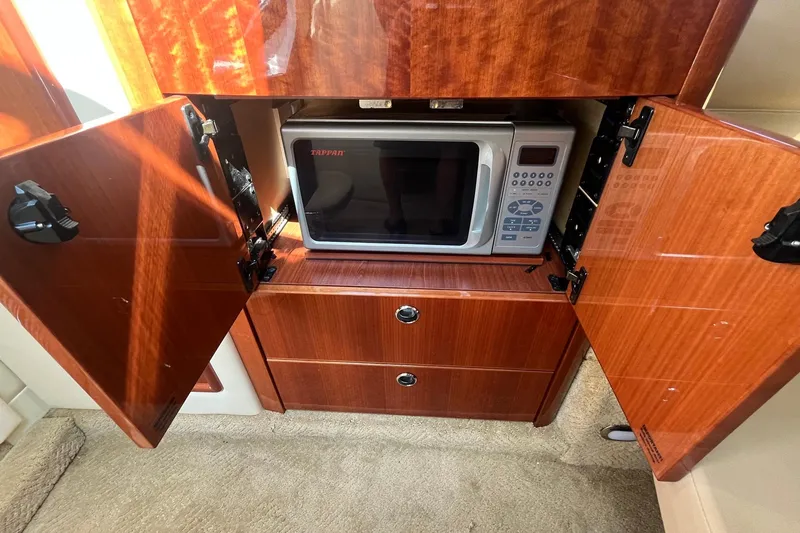 Slide: The Image of Wooden cabinet with open doors revealing a microwave inside a 2008 Cobalt 323. - 31