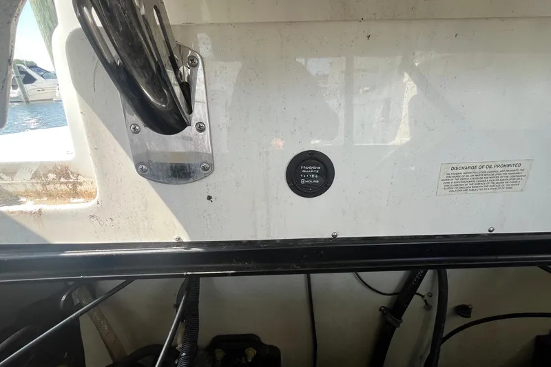 Slide: The Image of 2008 Cobalt 323 boat dashboard with hour meter and oil discharge warning. - 24