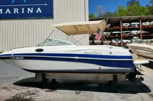 The Image of 2007 NauticStar 230 SL Sport Deck I/O boat with canopy, docked at marina. - 0
