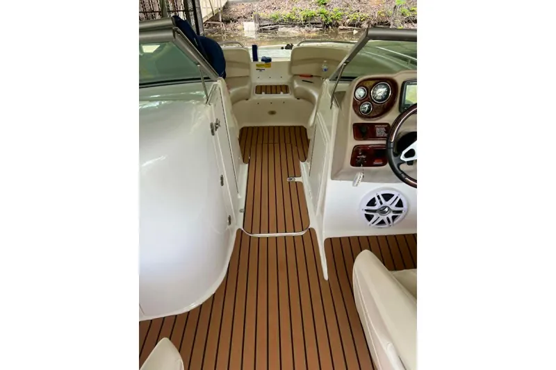 Slide: The Image of 2007 NauticStar 230 SL Sport Deck I/O interior with wood-style flooring and dashboard controls. - 2