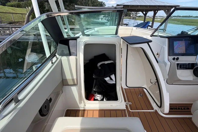 Slide: The Image of 2022 Boston Whaler 240 Vantage boat interior with storage compartment and navigation system. - 18