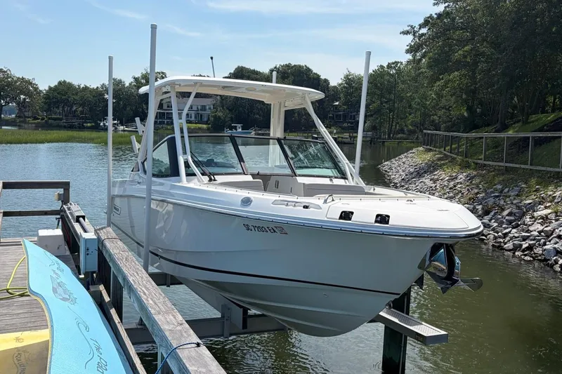 Slide: The Image of 2022 Boston Whaler 240 Vantage boat docked on a lift by a scenic river. - 4