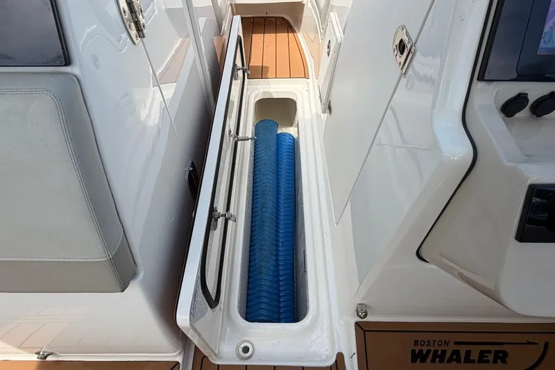 Slide: The Image of 2022 Boston Whaler 240 Vantage boat storage compartment with blue fender inside. - 19