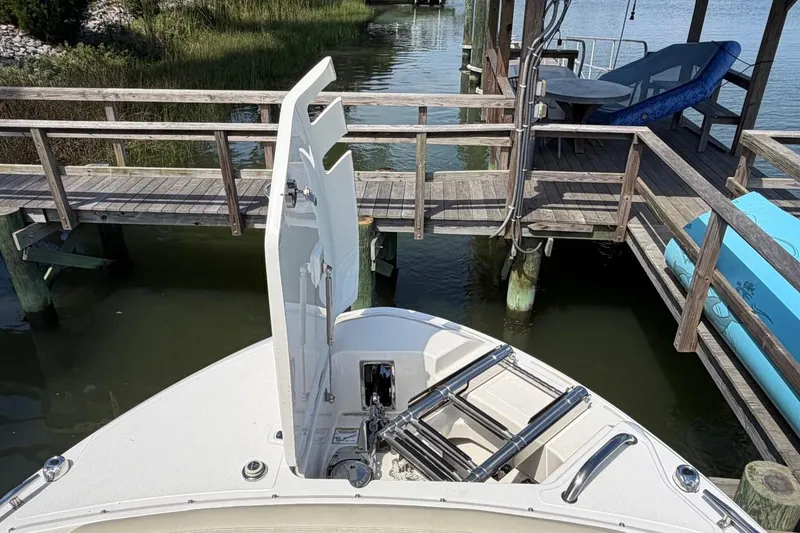 Slide: The Image of 2022 Boston Whaler 240 Vantage boat docked near wooden pier, open hatch visible. - 9